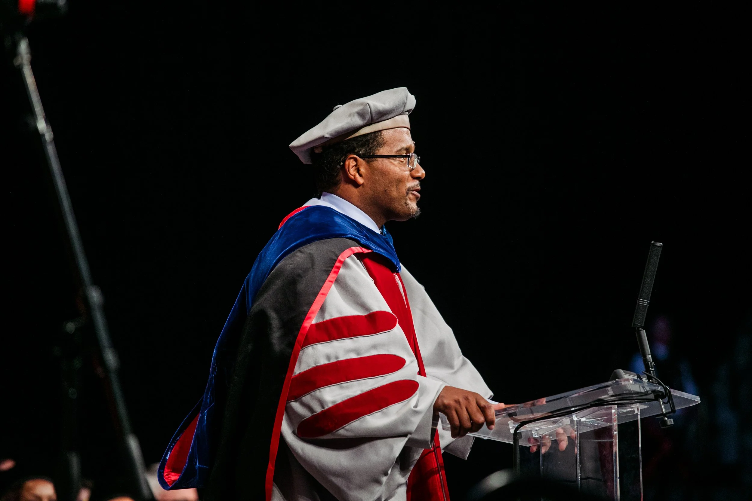 Darryll Pines, University of Maryland President, appears in cap and gown giving a speech at a commencement event.