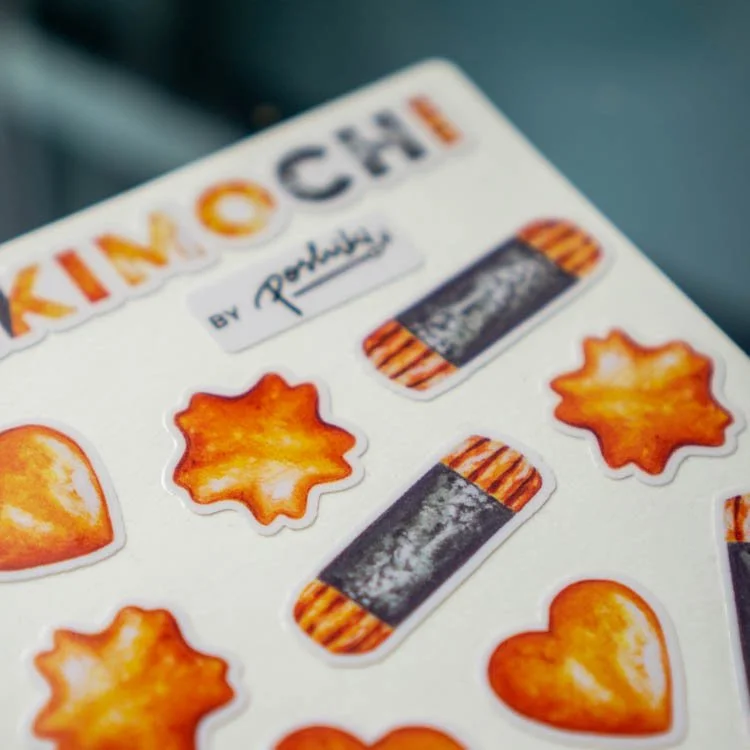 A close-up of a sticker sheet of watercolor illustrations of kakimochi (ararae).