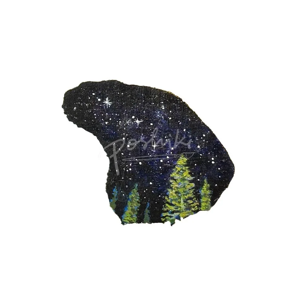 A hand-painted magnet in the shape of Lanai featuring a starry night sky and Cook pine trees.