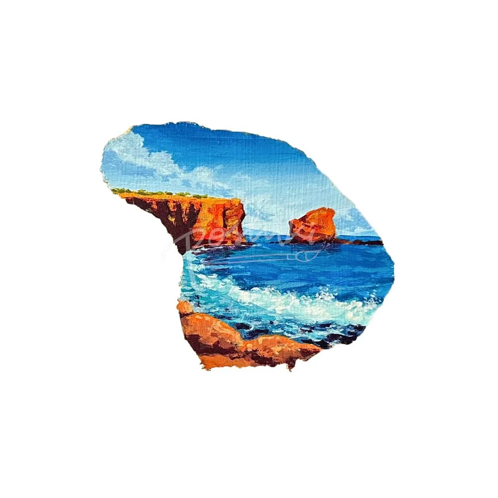 A hand-painted magnet in the shape of Lanai featuring a view of Sweetheart Rock (Puupehe).