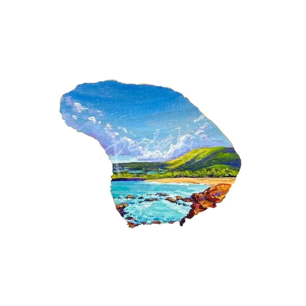 A hand-painted magnet in the shape of Lanai featuring a sunny day at Hulopoe Beach.