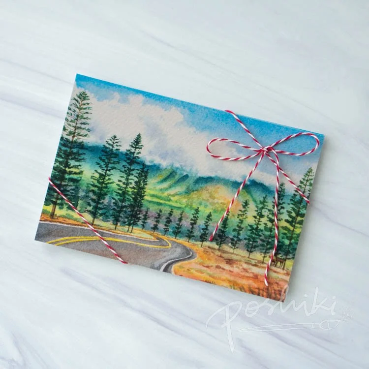 A watercolor landscape postcard featuring a view of the Palawai pine trees, mountains and Axis deer that are beloved on Lānaʻi.