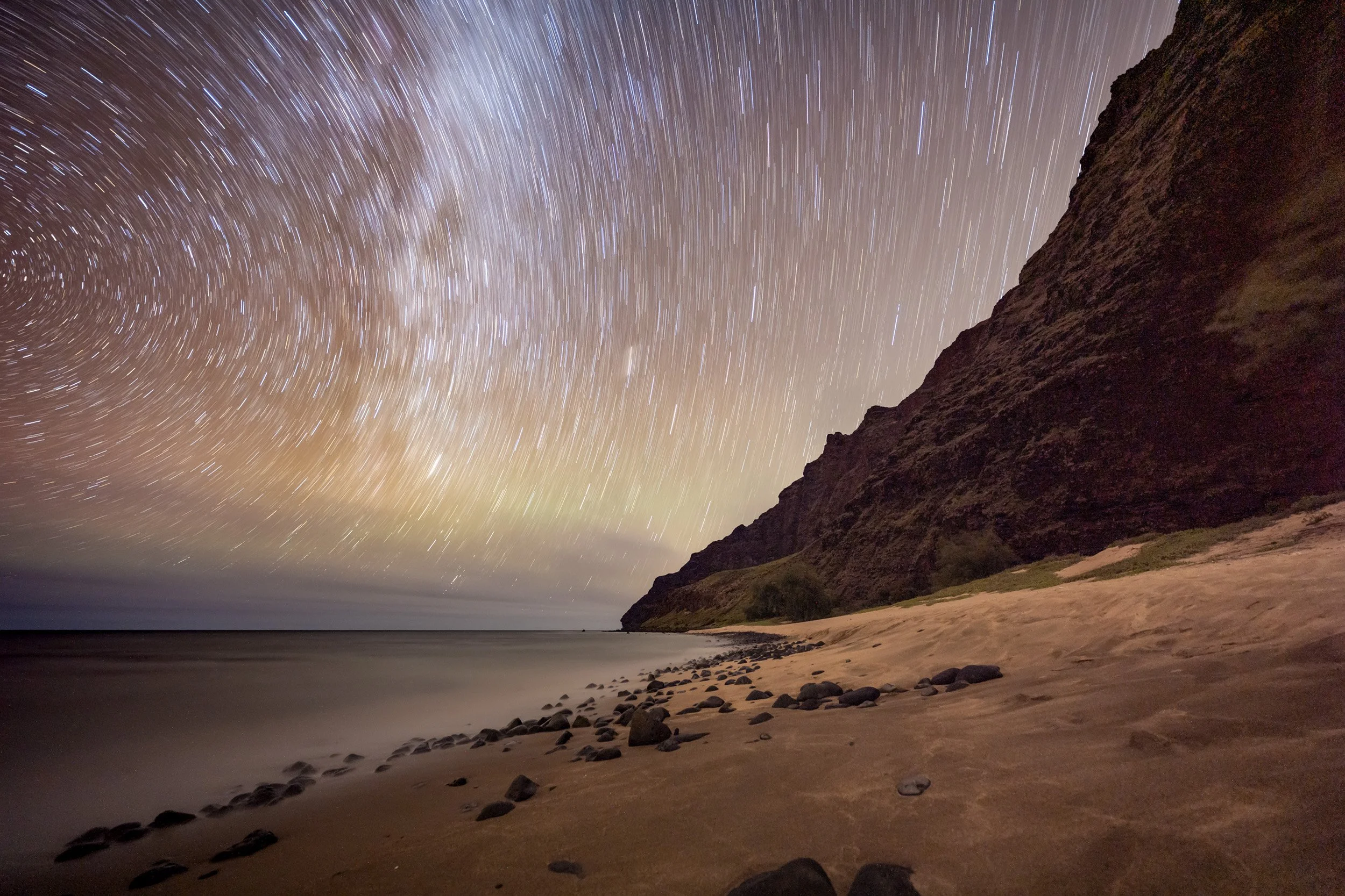 Star trails over Miloliʻi Beach along the Nā Pali Coast cliffs, Kauaʻi Hawaii night sky photography