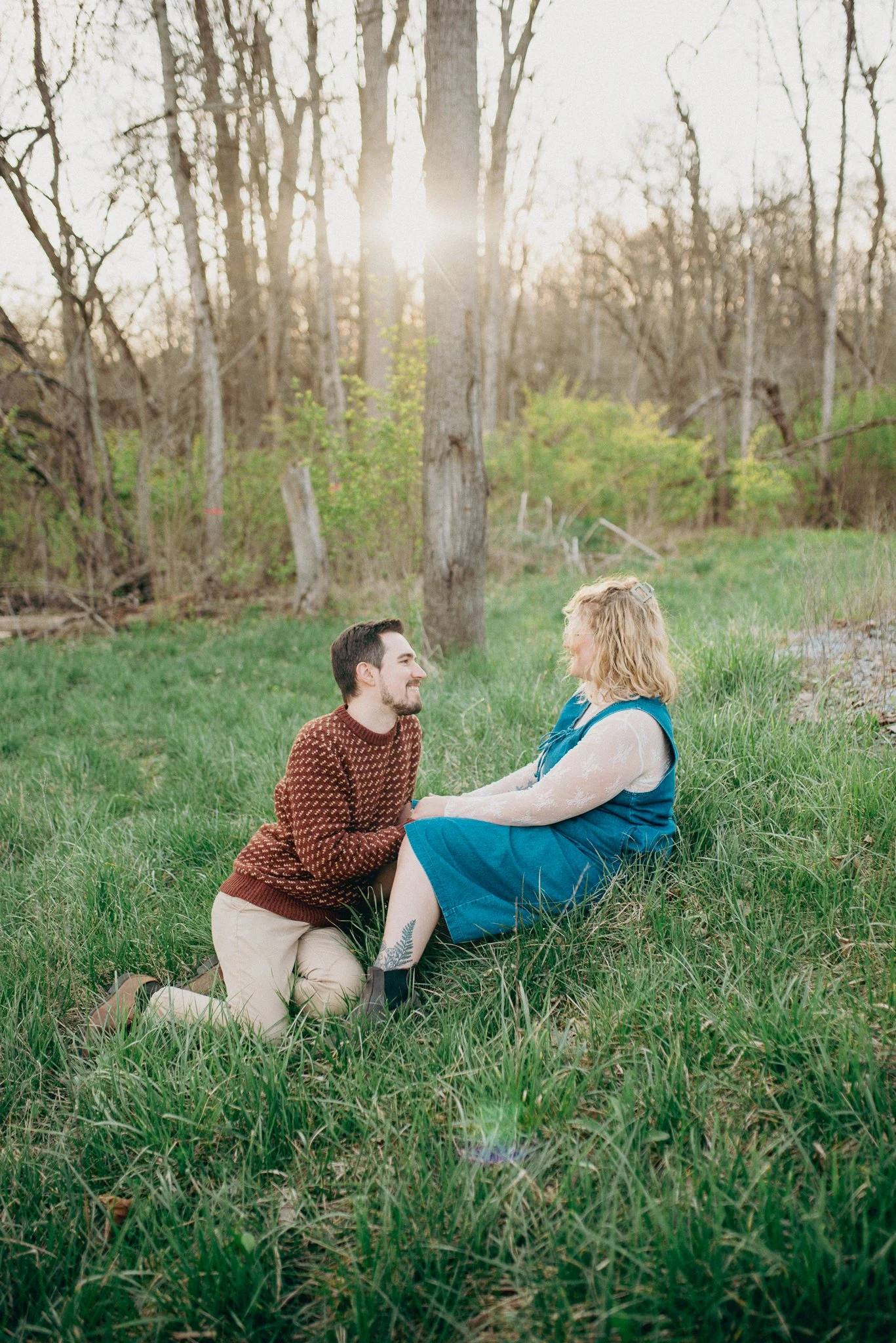 Engagement photoshoot of engaged couple sitting in grass during golden hour sunset. Richmond, Indiana. 