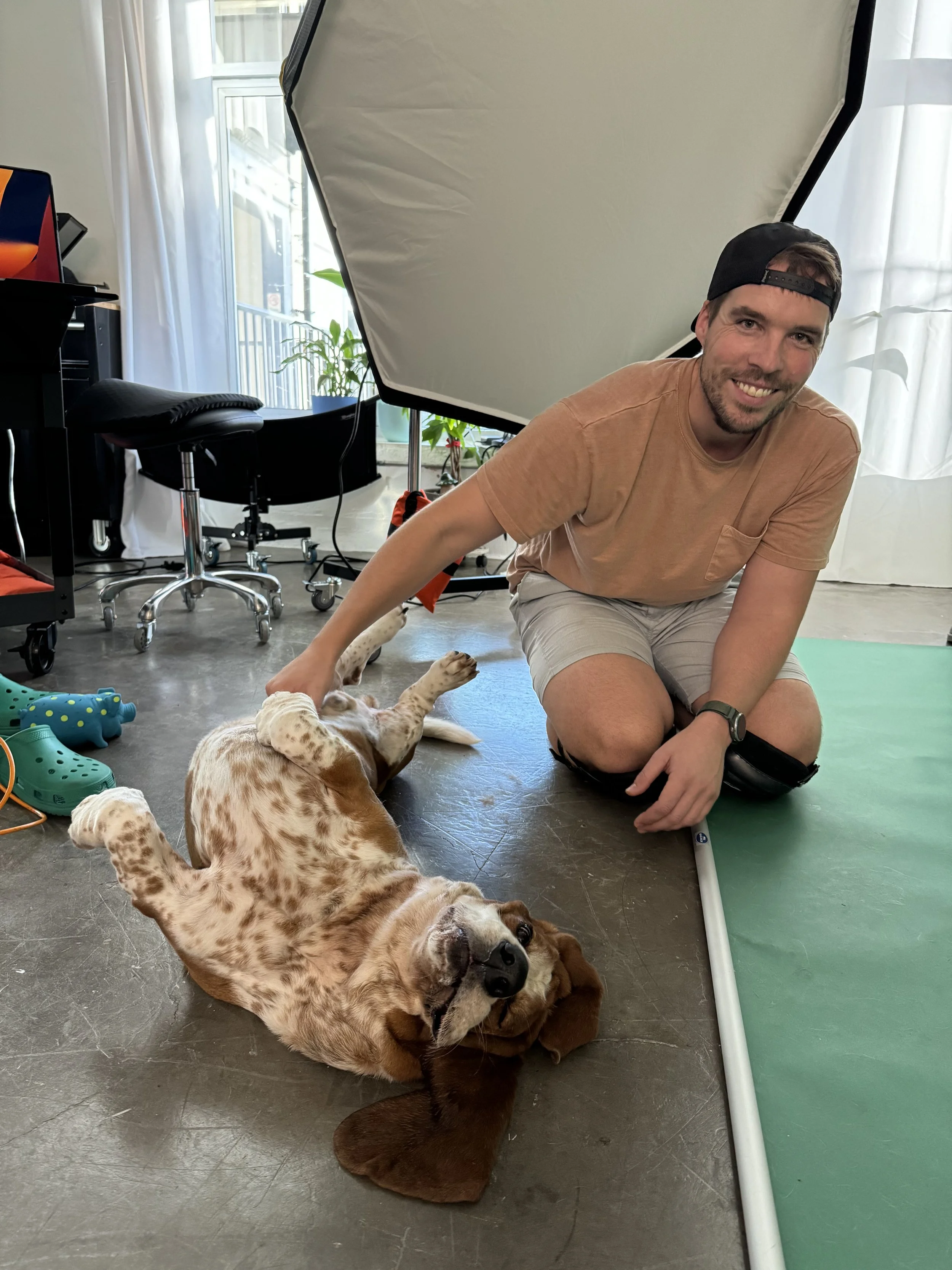 Fine art pet photographer Adam Claus petting basset hound dog in his LA studio