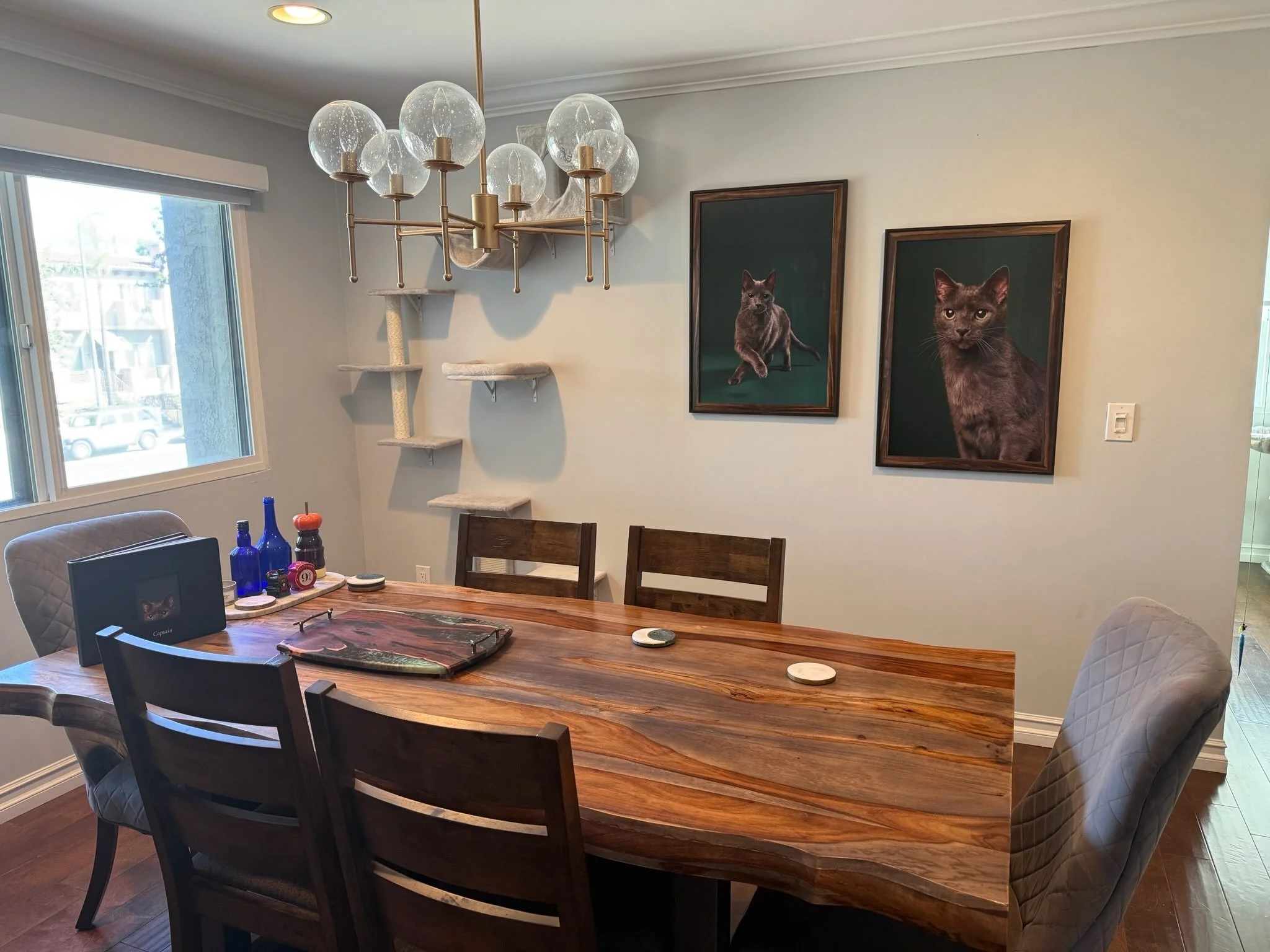 Photo of a dining room in Los Angeles with two framed Shuttermutt Photo portraits of a gray cat hanging on the wall above the table