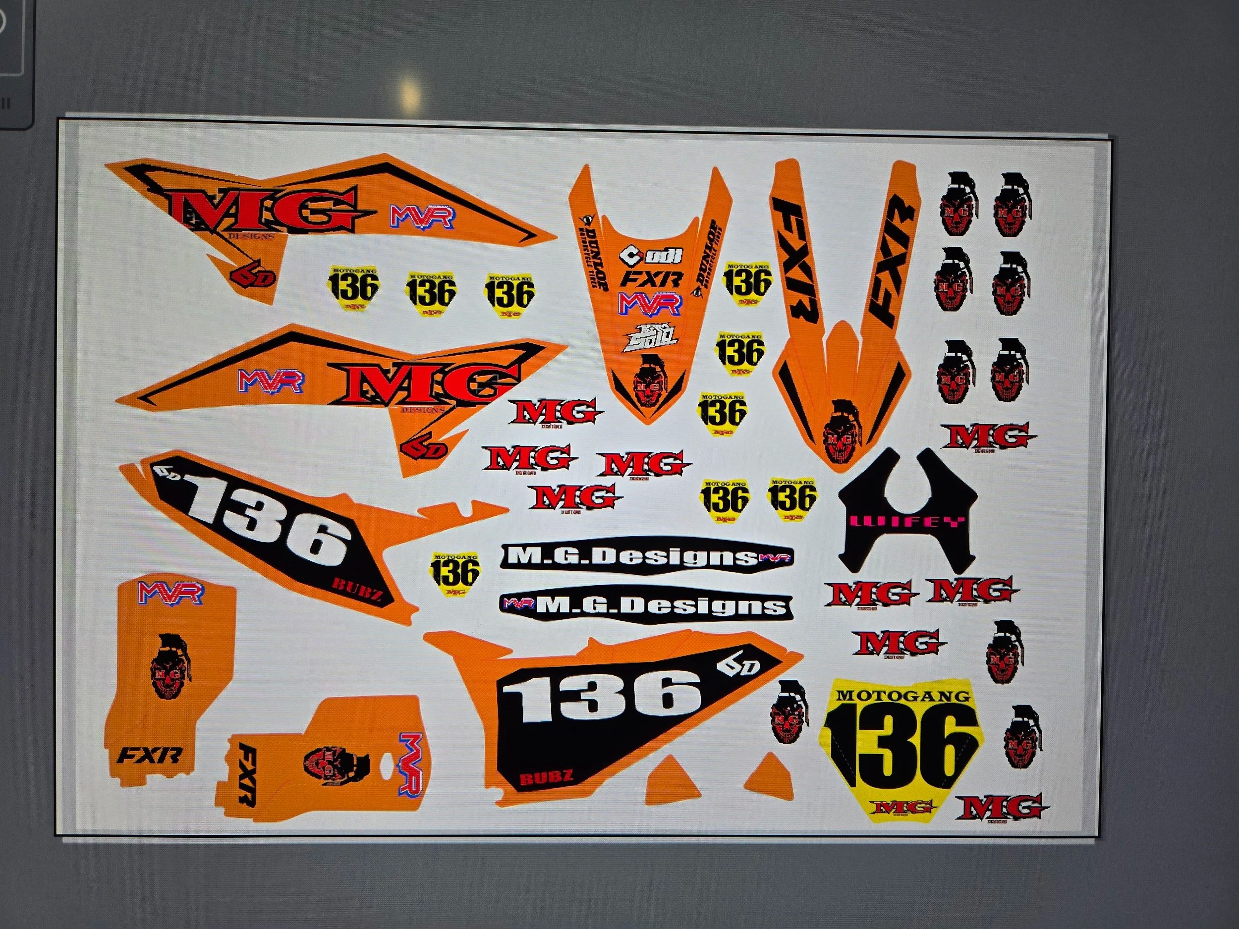 Decal sheet with logos and numbers for various motorcycle racers and brands, including FAX, Mega, MRF, and MOTOGAS.