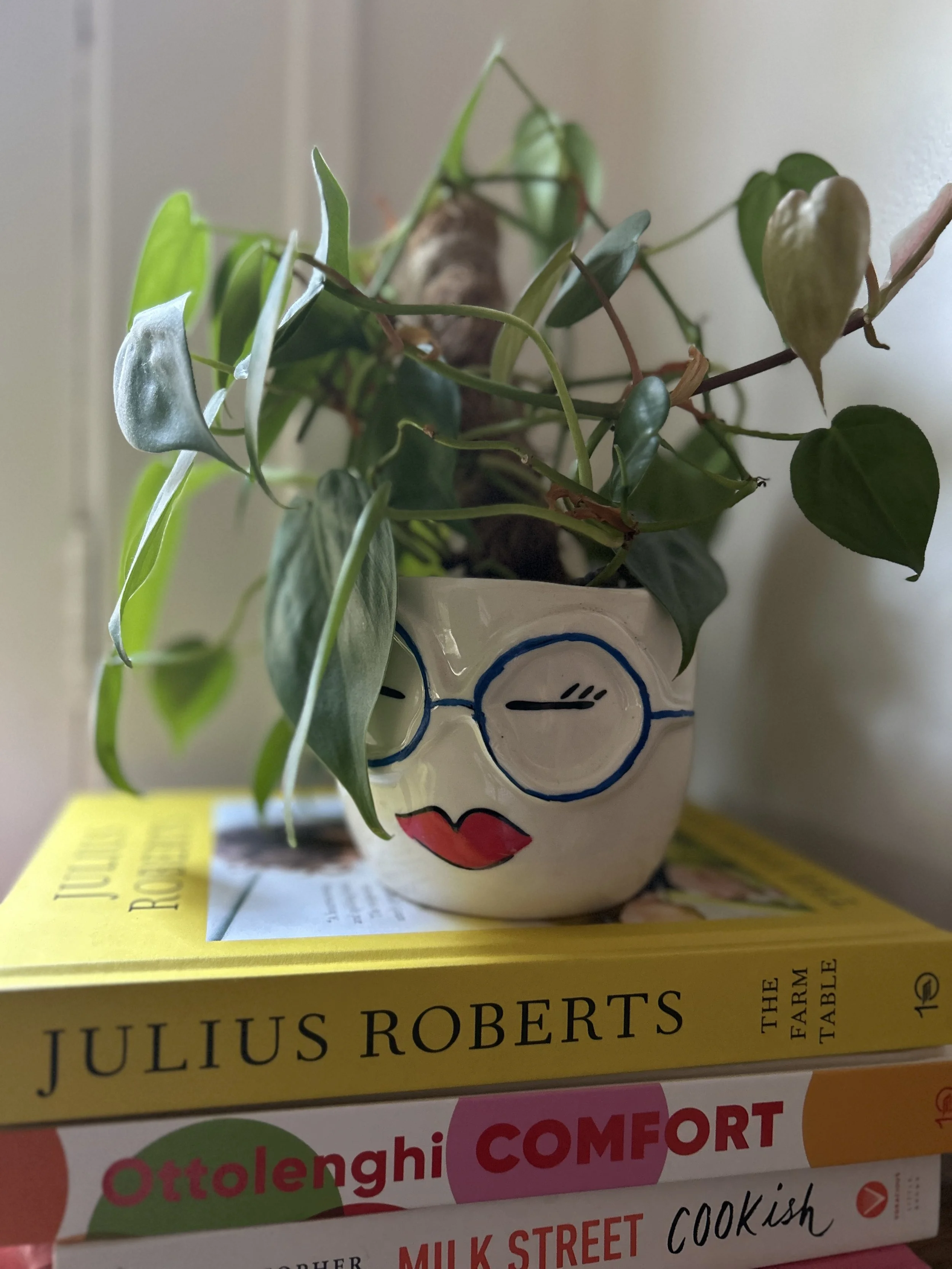 face planter with glasses and red lipstick on a stack of cookbooks