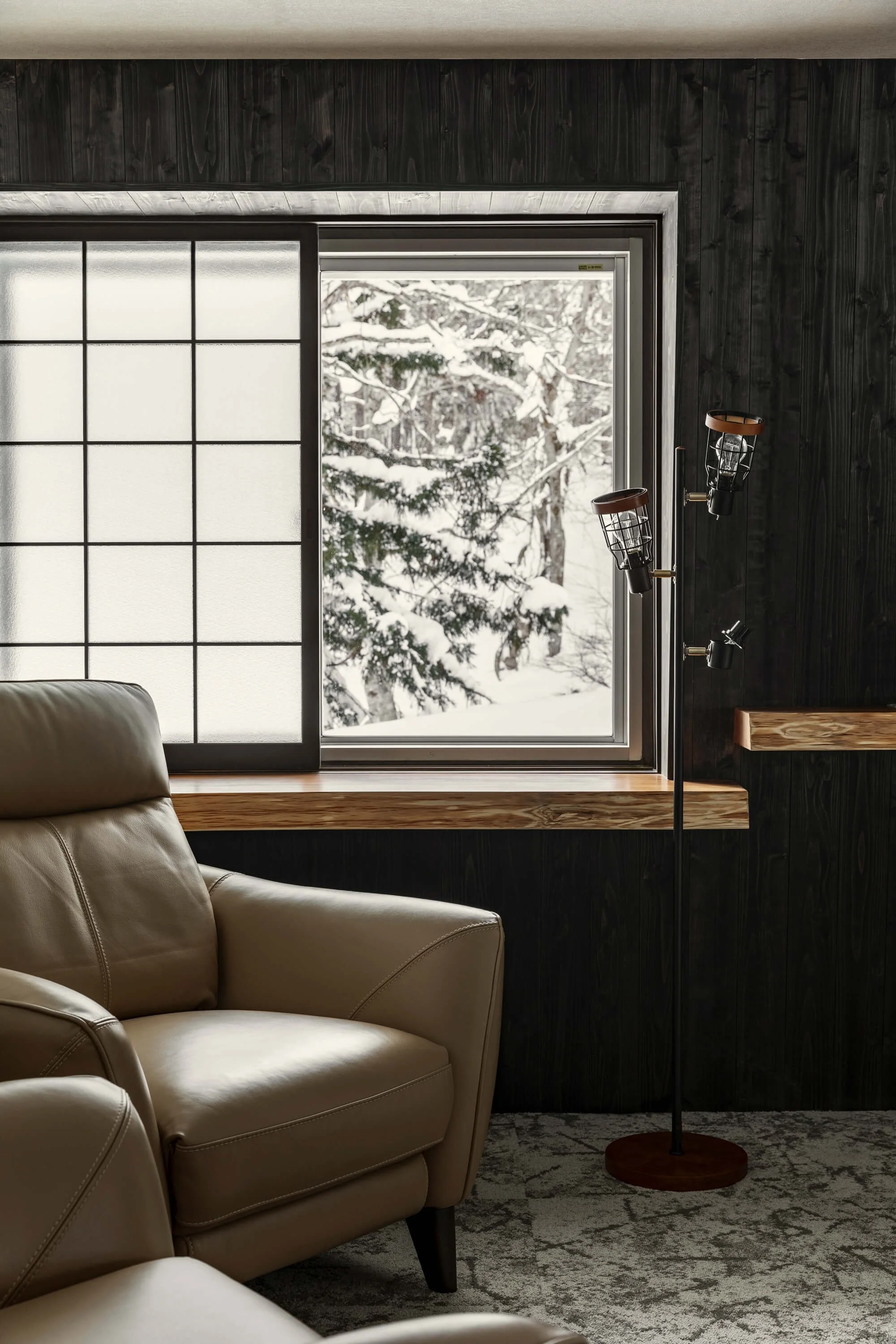 cozy sitting area looking out over snow covered trees and ski run