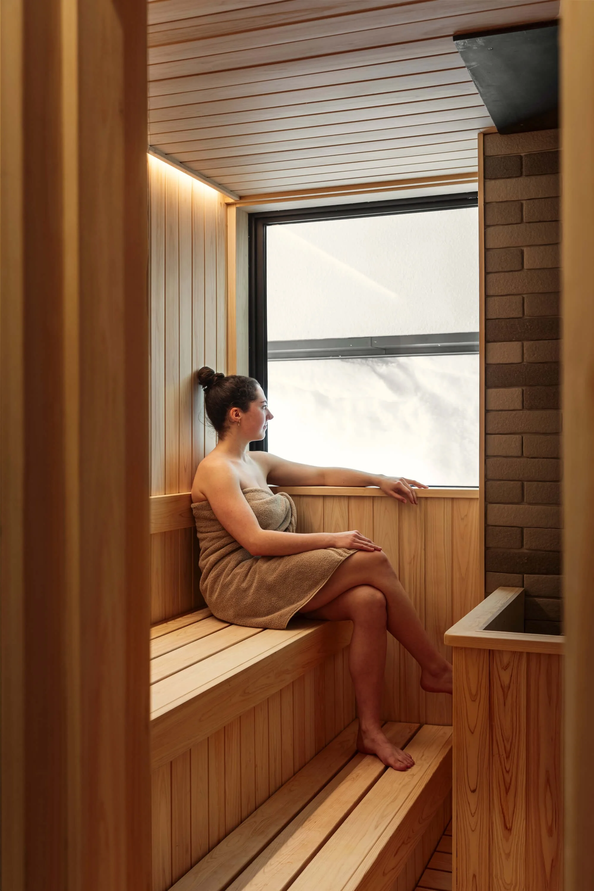 Woman relaxing in the hinoki wood sauna.