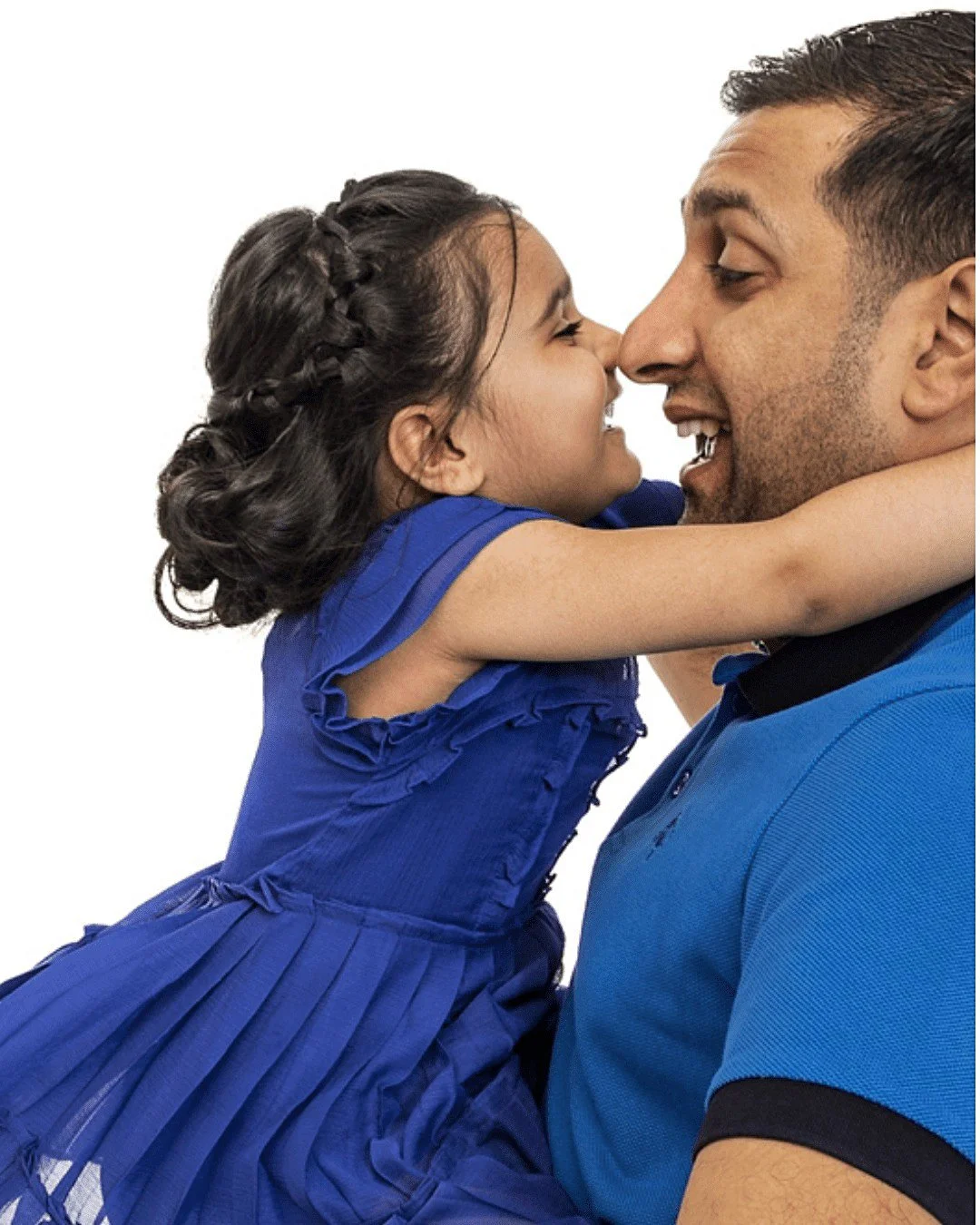 A girl with dark hair in braids wearing a blue dress hugging a man in a blue shirt, both smiling with their noses touching.