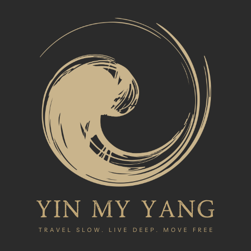 A stylized beige yin-yang symbol with the text "YIN MY YANG" and the phrase "Travel slow. Live deep. Move free" underneath, on a black background.