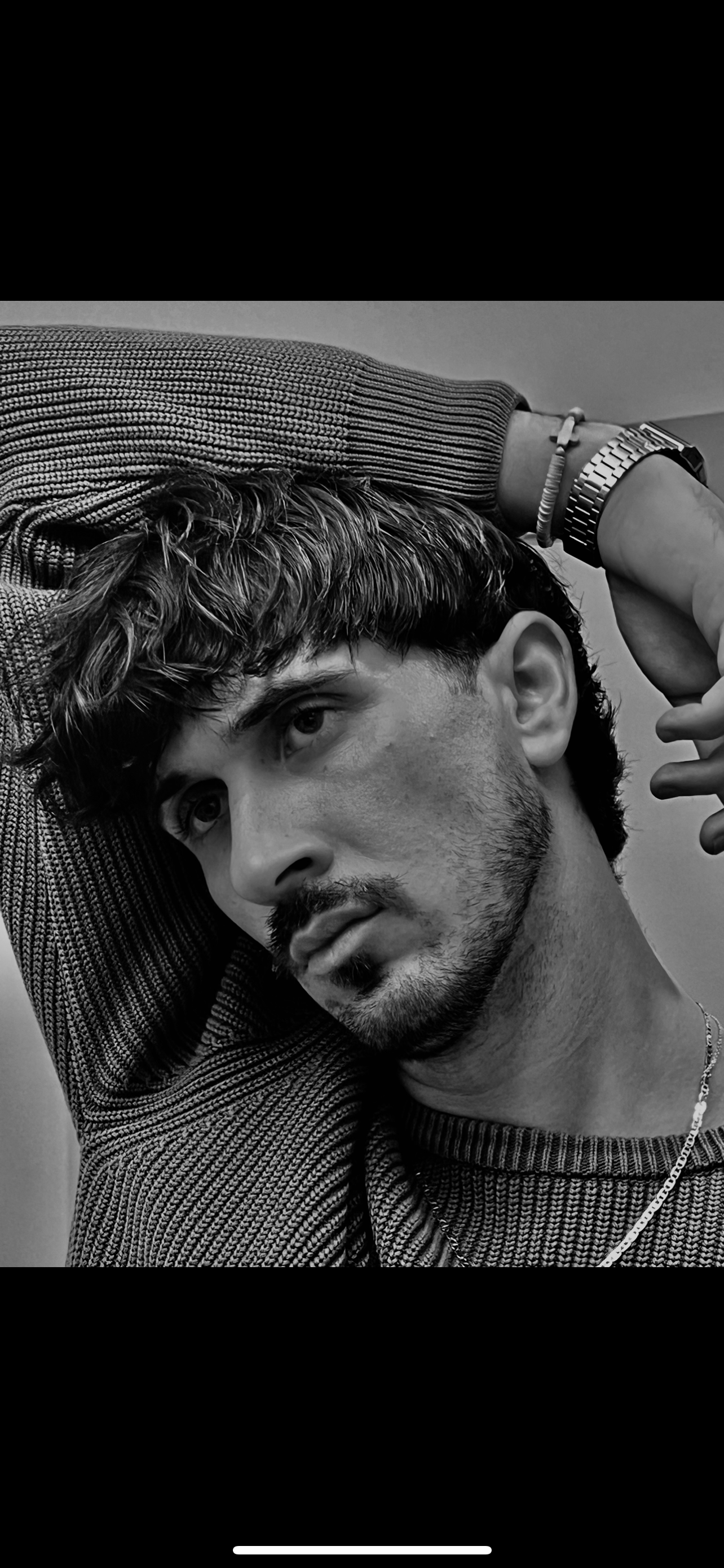 A man dressed as a golfer, wearing a white golf shirt and a dark green cap with sunglasses, standing outdoors on a sunny day with trees in the background.