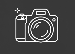 Outline of a camera with a large lens, a flash symbol, and a small icon on the top left.