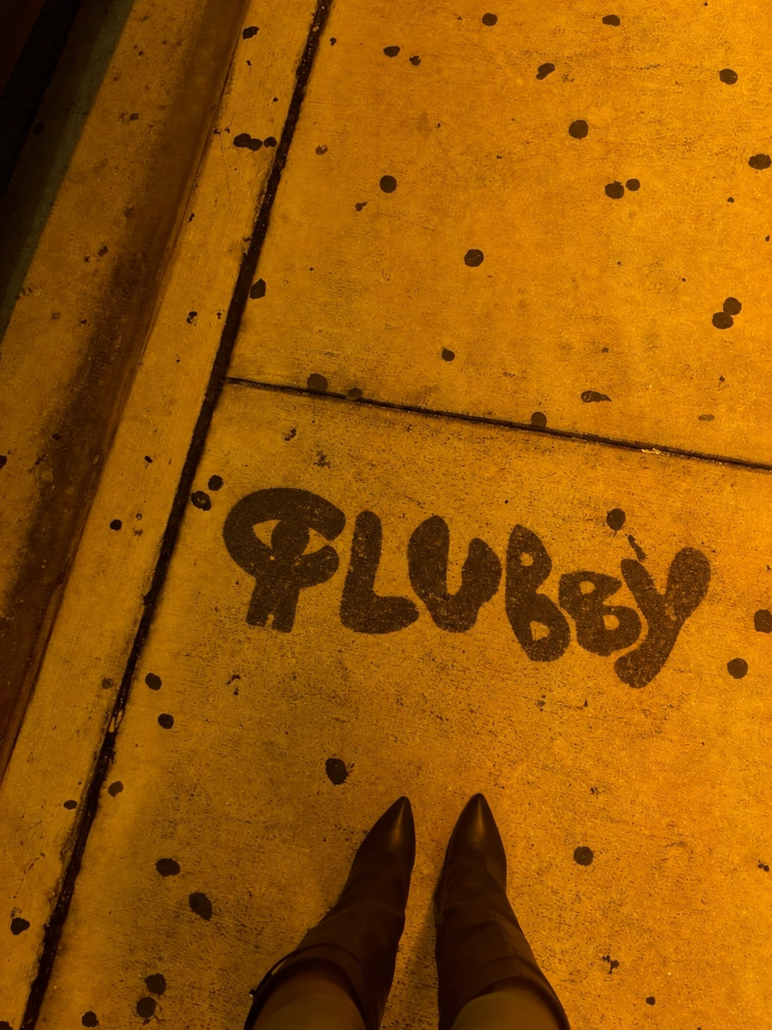 Graffiti nocturno bajo luz ámbar.png