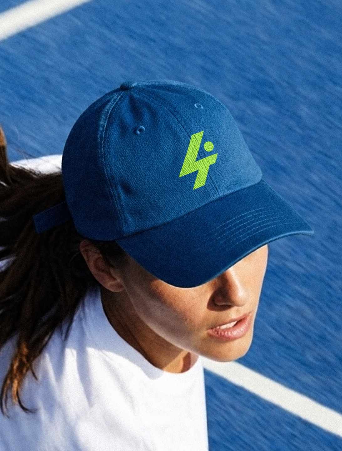 Atleta con gorra neón en cancha azul.png