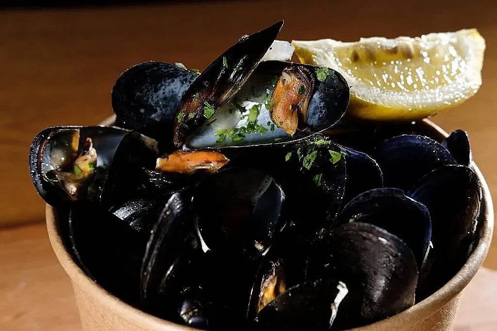 Ciotola di cozze con limone e prezzemolo.