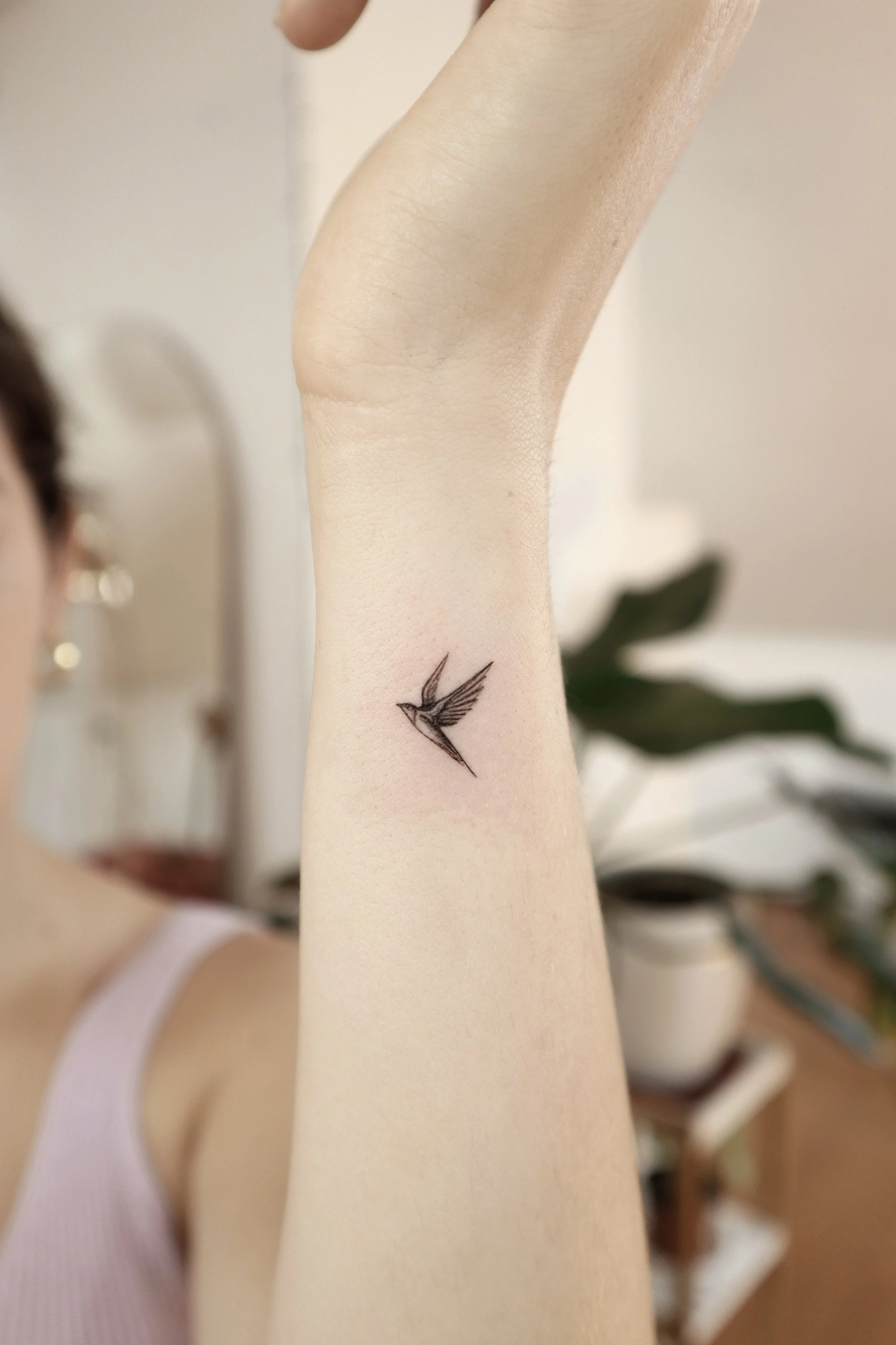 Tatuaje de un colibrí en el antebrazo.
