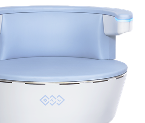 Close-up of a light blue medical or laboratory machine with a rounded surface and a small yellow testing tube attached to a white plastic holder on the side.