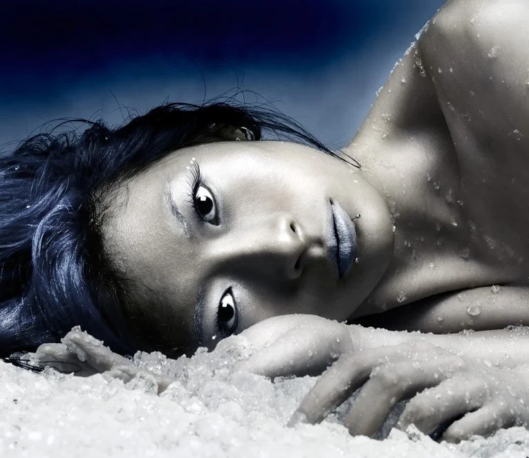 A woman lying on snow after a CRYO Q Facial.