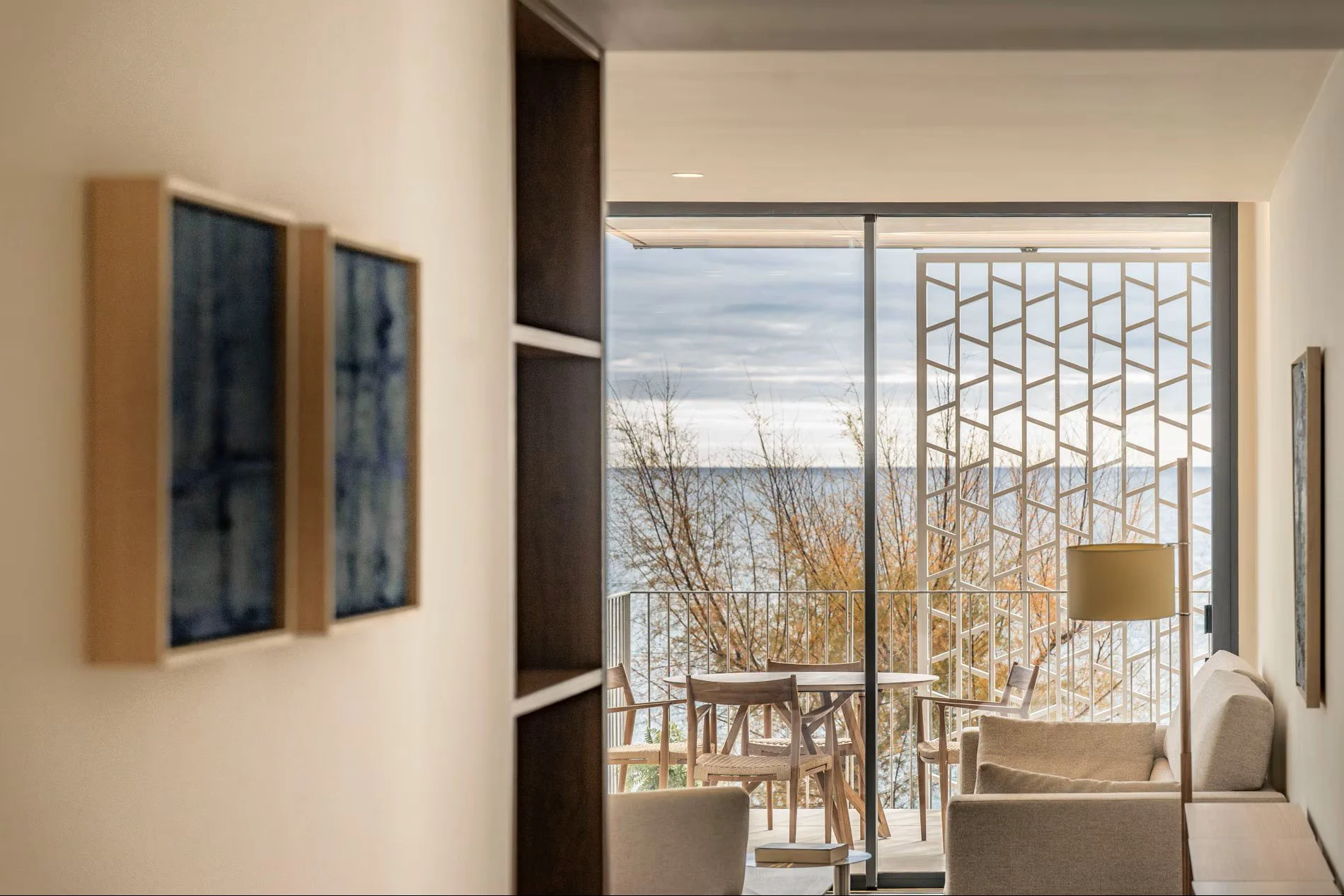 Vista desde interior hacia terraza de Sorra Mar i Cel con celosía de fachada y mar de fondo. Relación entre espacio privado y paisaje mediterráneo. Proyecto de Escabeche Studio.