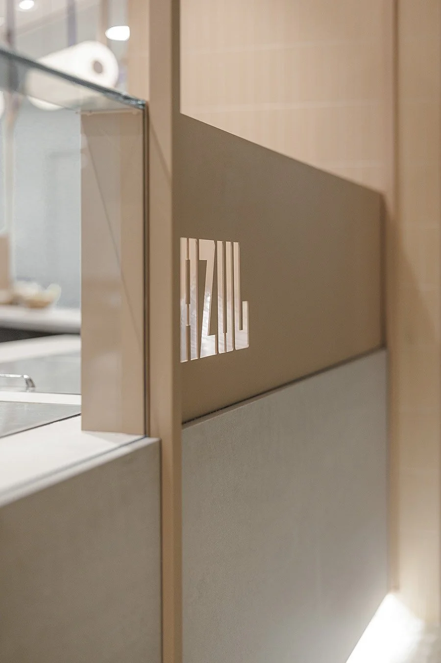 Vista del interior de un restaurante o cafetería con un cartel que dice 'IZAKAYA' en la pared de madera clara.