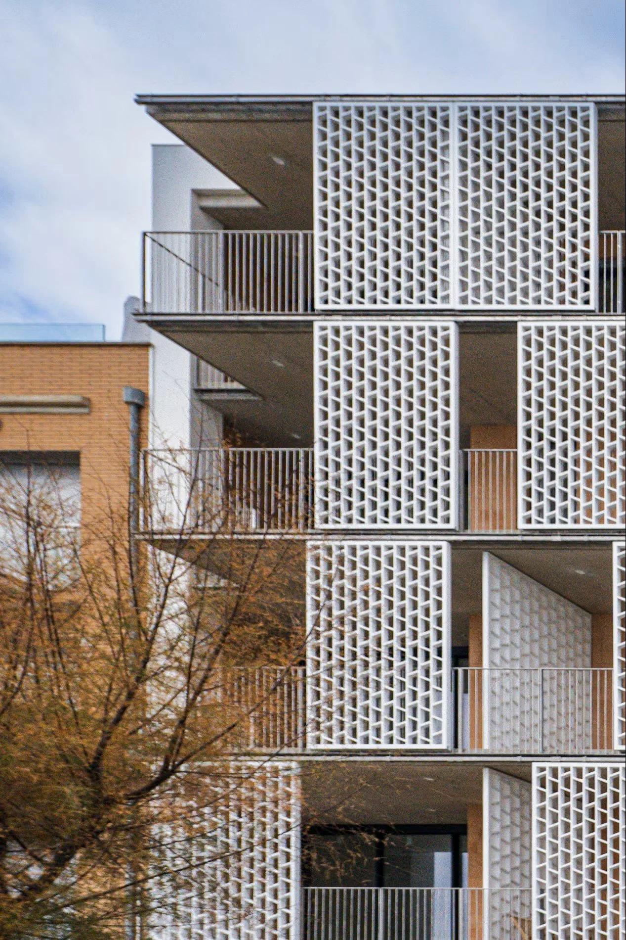 Vista de fachada lateral y entorno urbano de Sorra Mar i Cel, Sant Antoni de Calonge. Integración del edificio de apartamentos turísticos en el paisaje costero. Escabeche Studio.