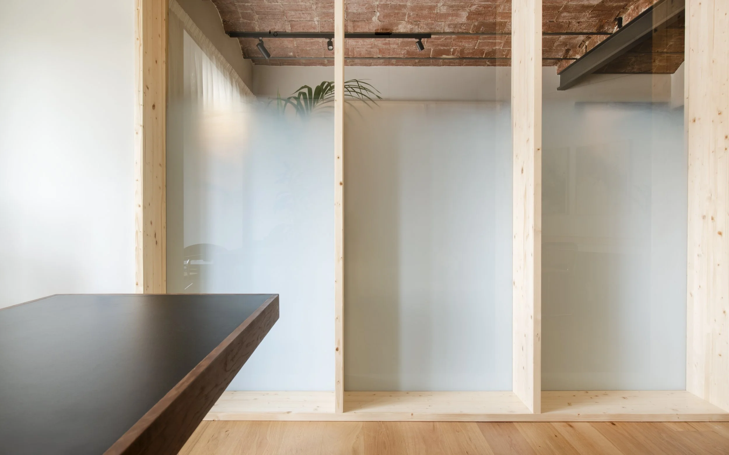 Detalle de cabina o módulo individual de madera con iluminación cálida en Vértigo Vida, Barcelona. Espacio para sesiones privadas, interiorismo de Escabeche Studio.
