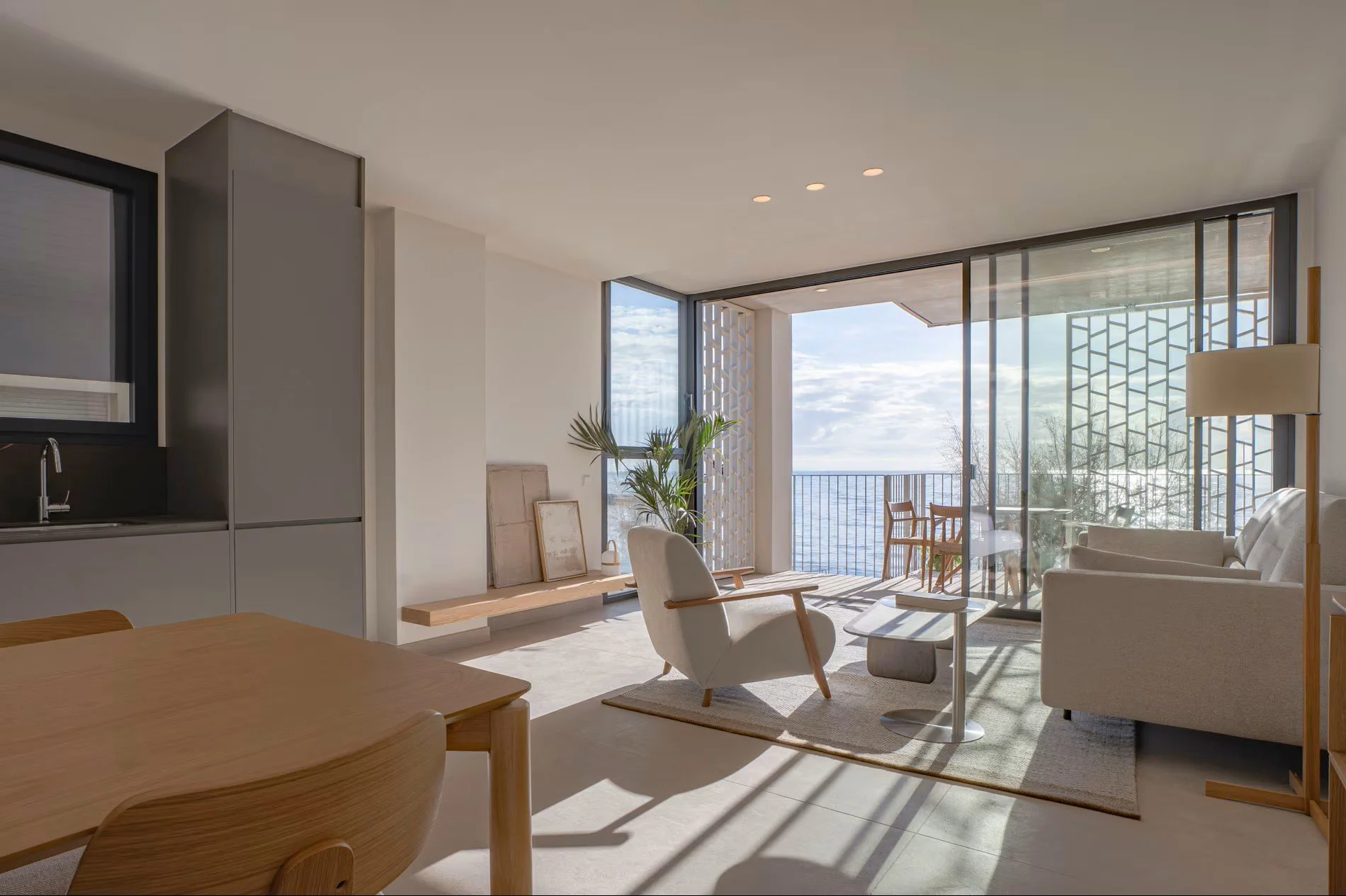 Zona de estar con luz natural y vistas abiertas al mar en apartamento de Sorra Mar i Cel, Sant Antoni de Calonge. Interiorismo para alojamiento turístico Costa Brava, Escabeche Studio.