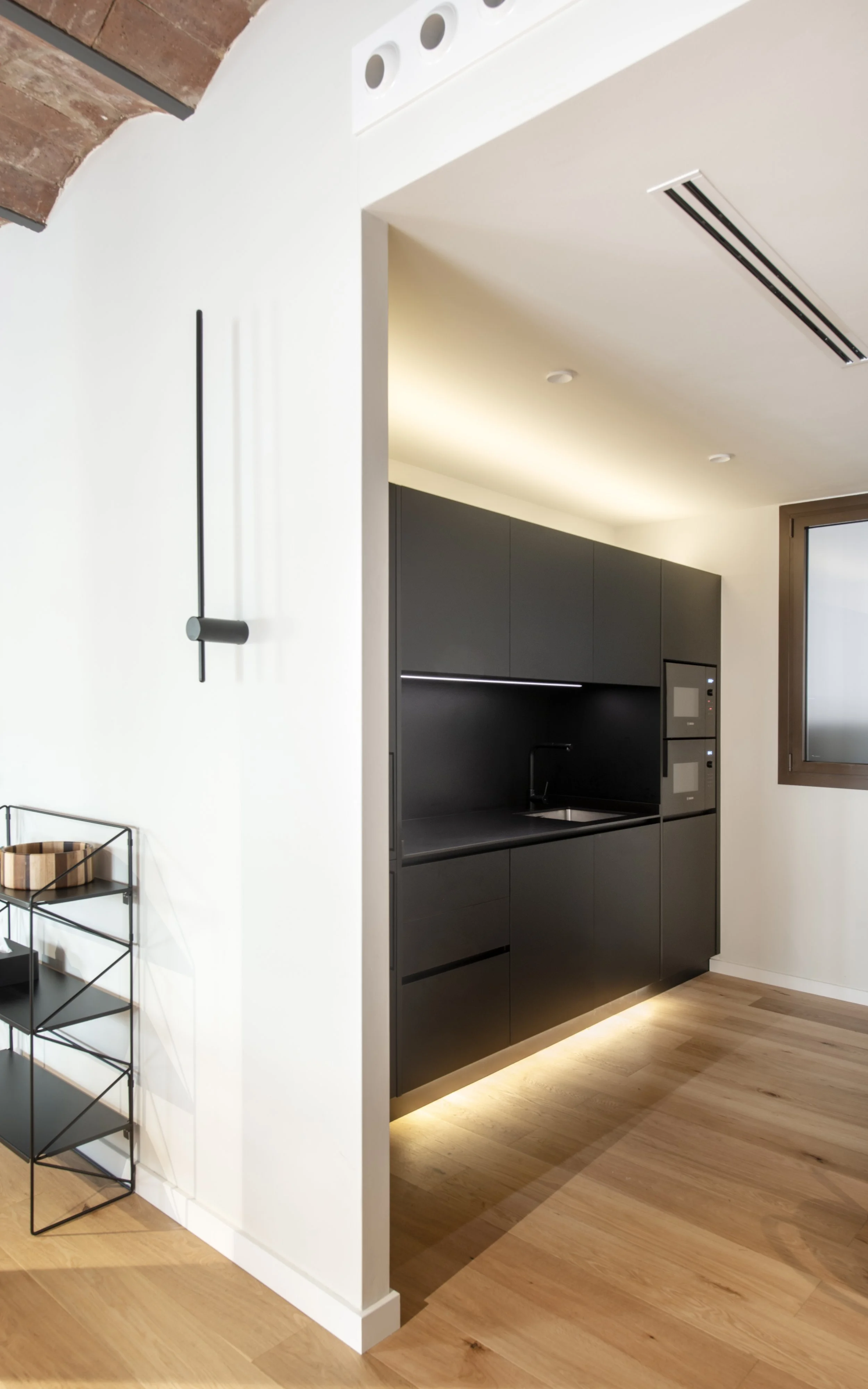 Detalle de iluminación empotrada y panel de madera en Vértigo Vida, centro terapéutico en Barcelona. Acabados cálidos y cuidados por Escabeche Studio.