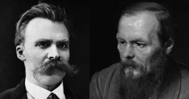 Black and white photo of two men, one with a large handlebar mustache and slicked-back hair, and the other with a beard and receding hairline.