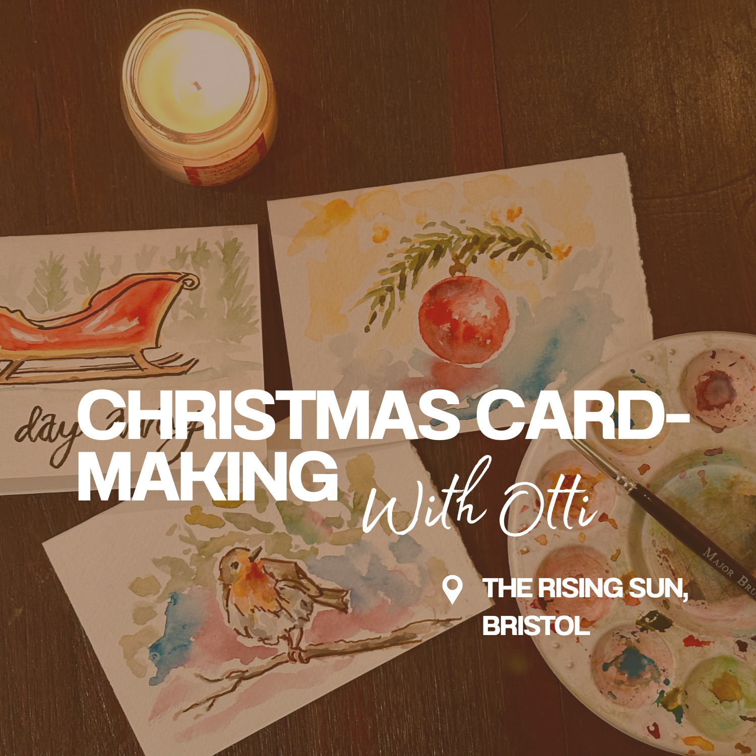 Watercolor Christmas cards with festive themes, a lit candle, and a paint palette with brushes on a wooden table.
