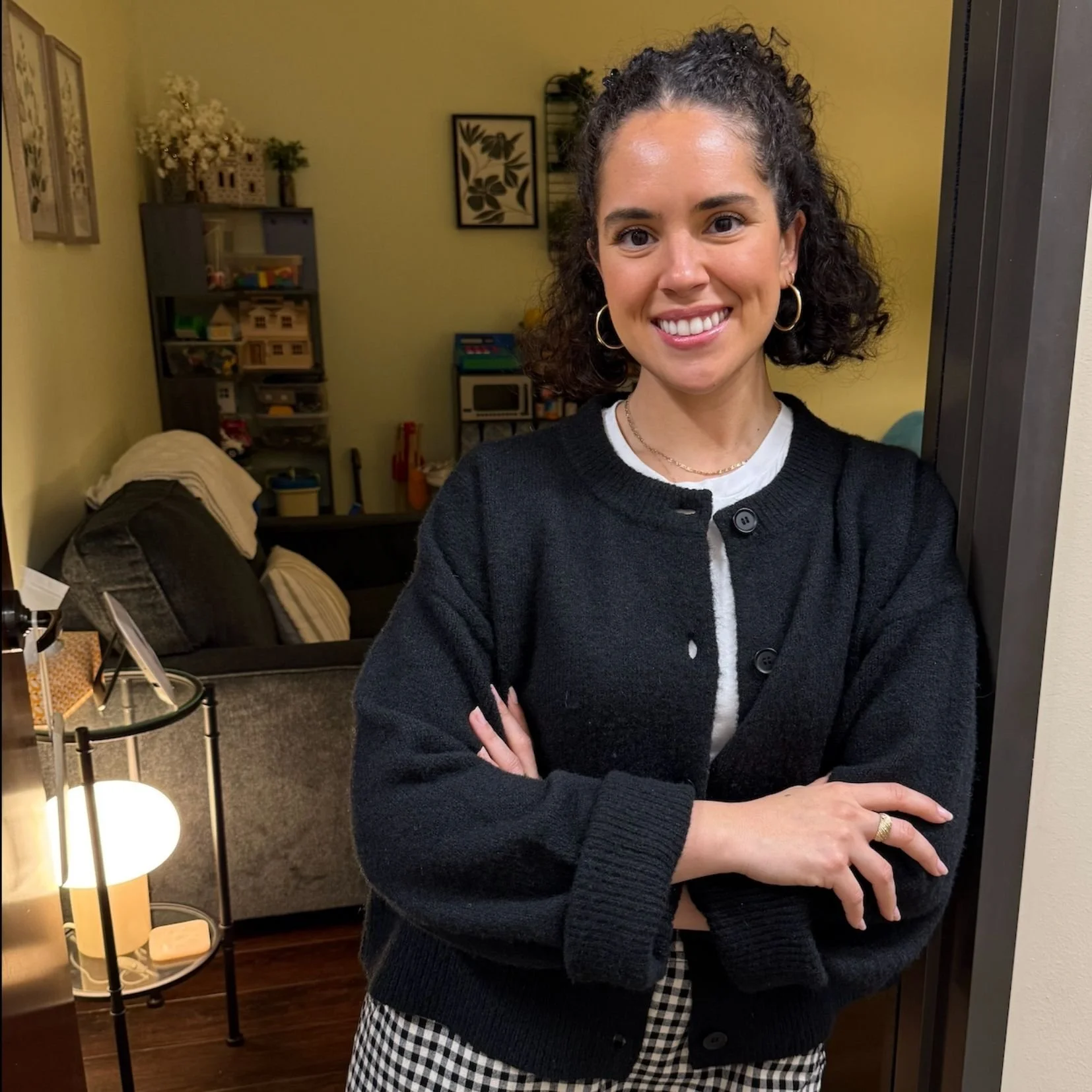 Camila stands in the doorway with an inviting smile outside of her office