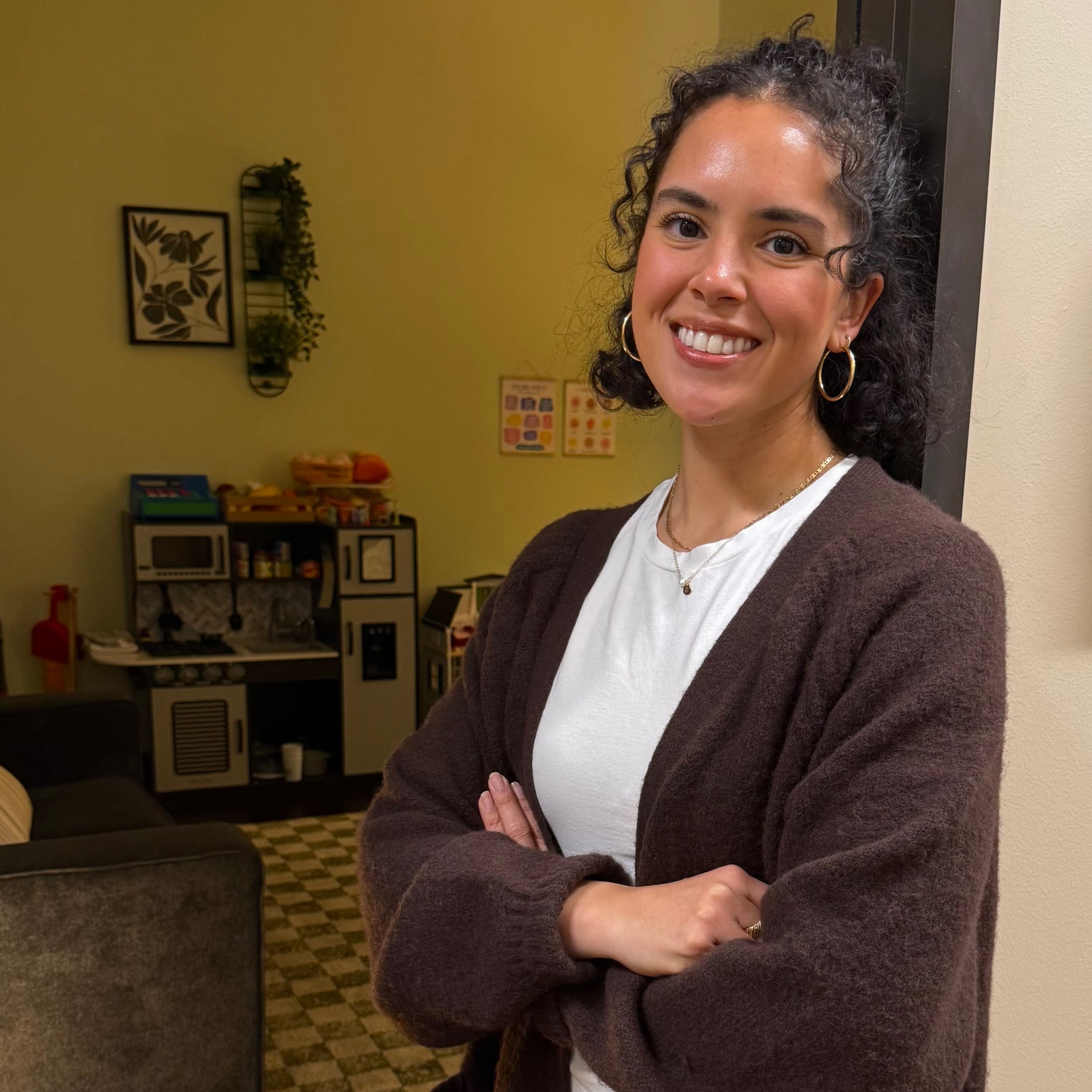 Camila stands in the doorway of her office