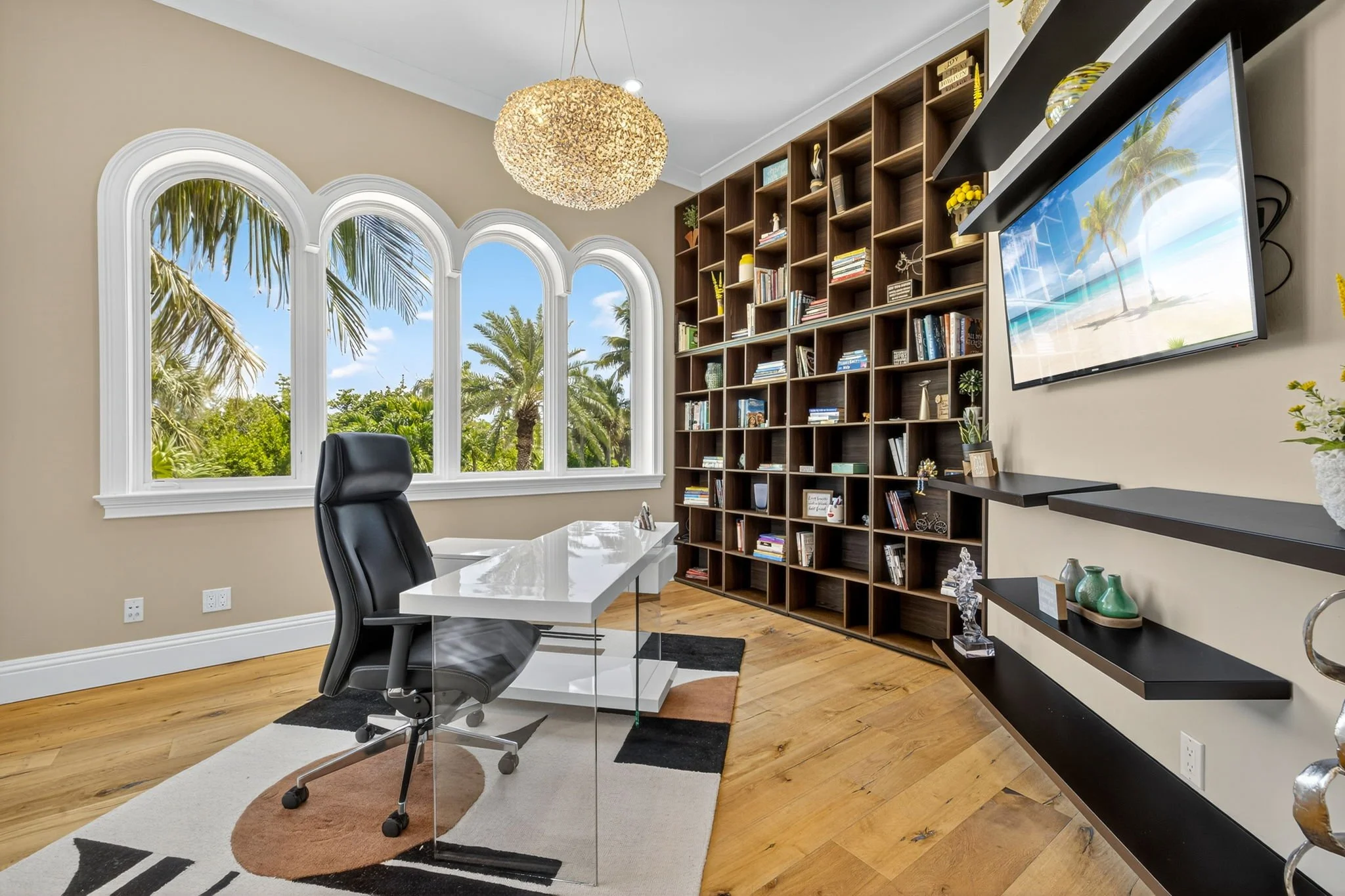 Real estate interior media by VisionBoost Studios featuring a coastal home office with ergonomic desk setup and palm tree views.