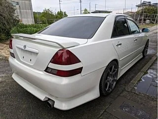 Classic JDM car exterior with clean body lines and factory aero kit