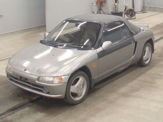 A silver and black Honda S2000 convertible sports car parked indoors.