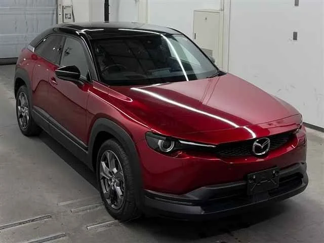 Red Mazda SUV parked in a garage with a black roof and black accents.