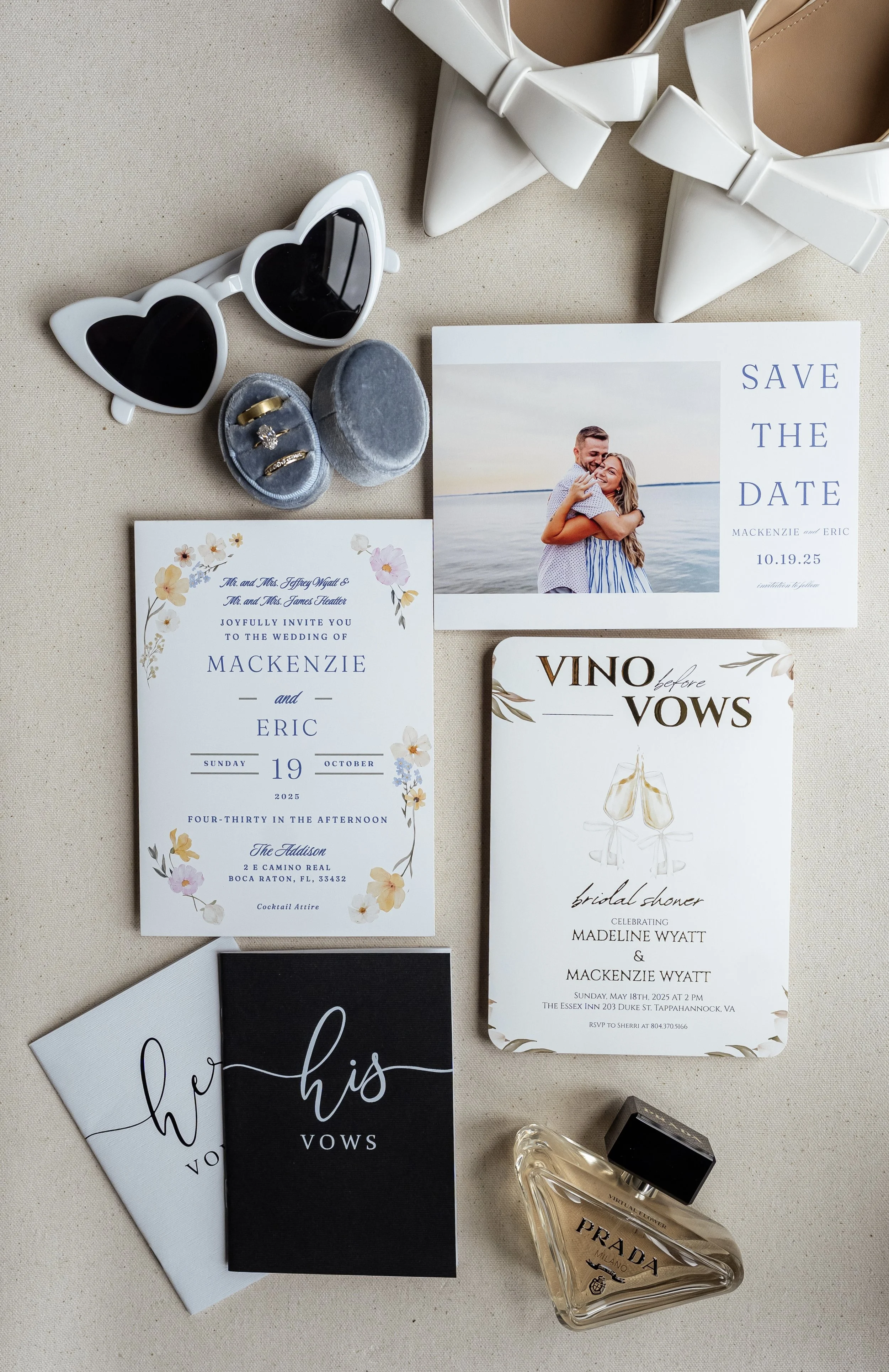 Wedding invitation set, heart-shaped sunglasses, a pair of white high heel shoes with bows, a perfume bottle, and some rings in a velvet box.