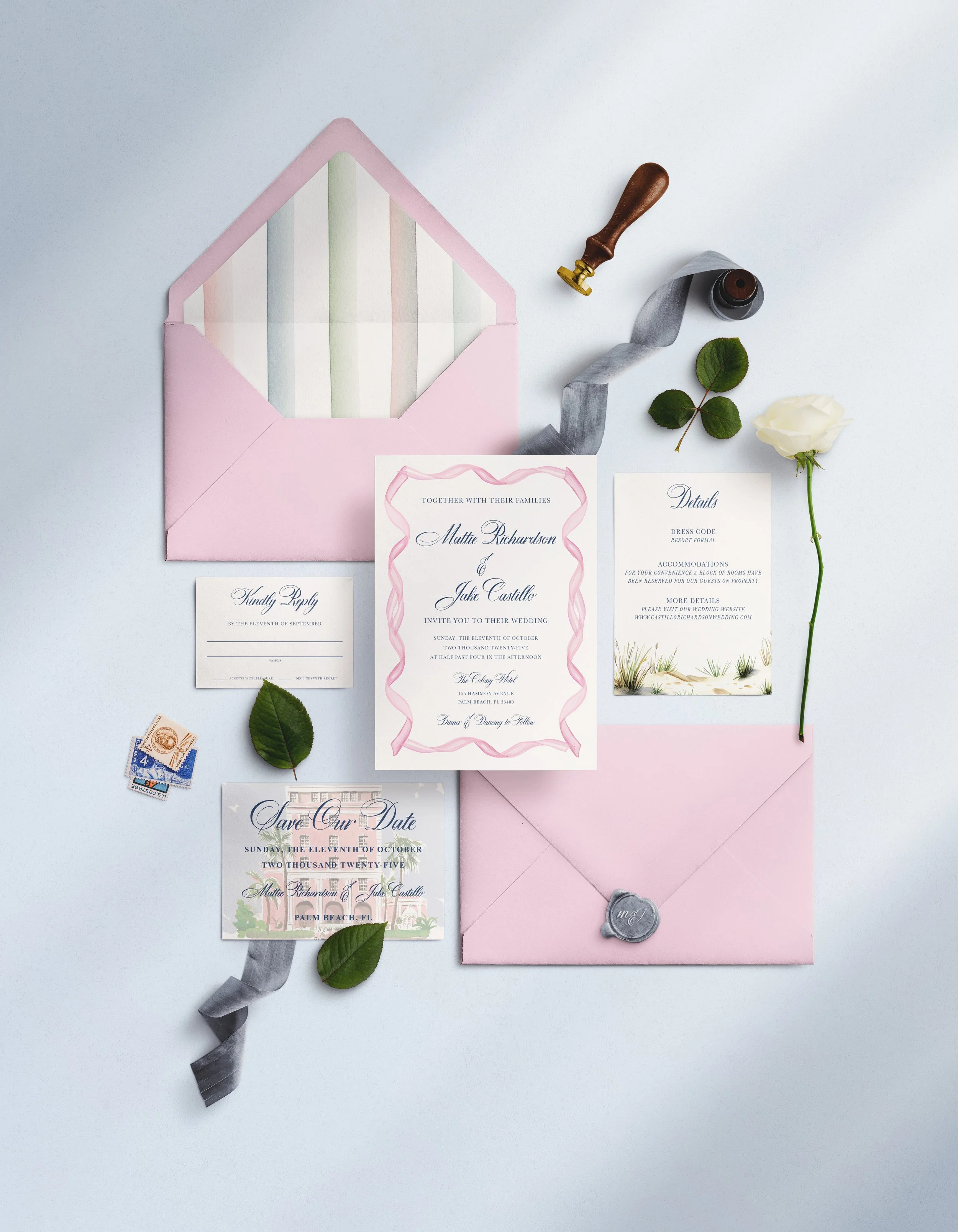 Wedding invitation items including an envelope, printed invitation card with pink border, and RSVP card, along with decorative leaves, a white rose, a gray ribbon, a wax seal, and a postage stamp on a light background.