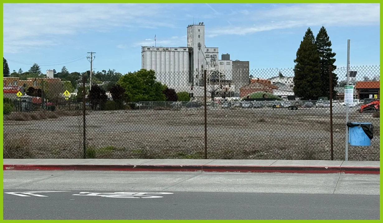  Behind the train depot we see acres of vacant land, wrapped in a chain‑link fence. 