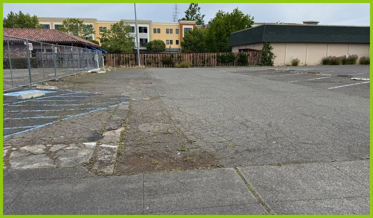  We round the corner on Fourth Street to an empty parking lot of cracked asphalt. 
