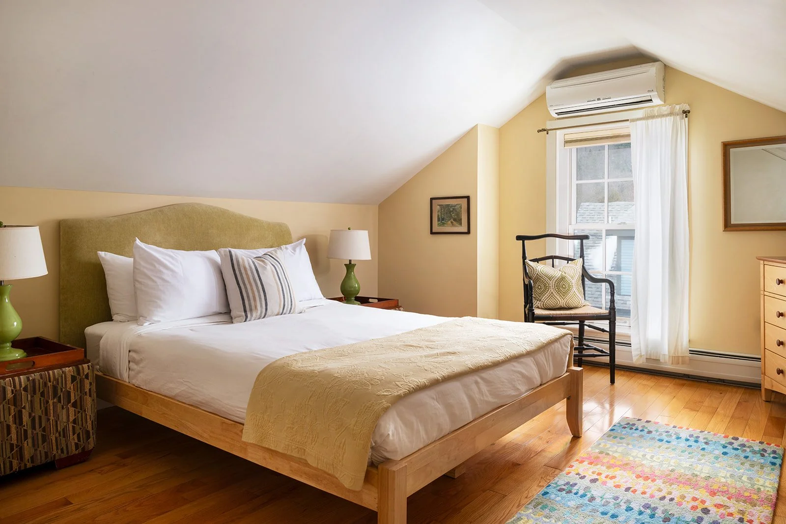 East queen bedroom in Orion's Retreat featuring bright natural light, wood floors and comfortable seating