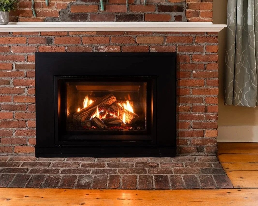 Gas fireplace in Parlor Suite with exposed brick hearth creating a warm and inviting atmosphere