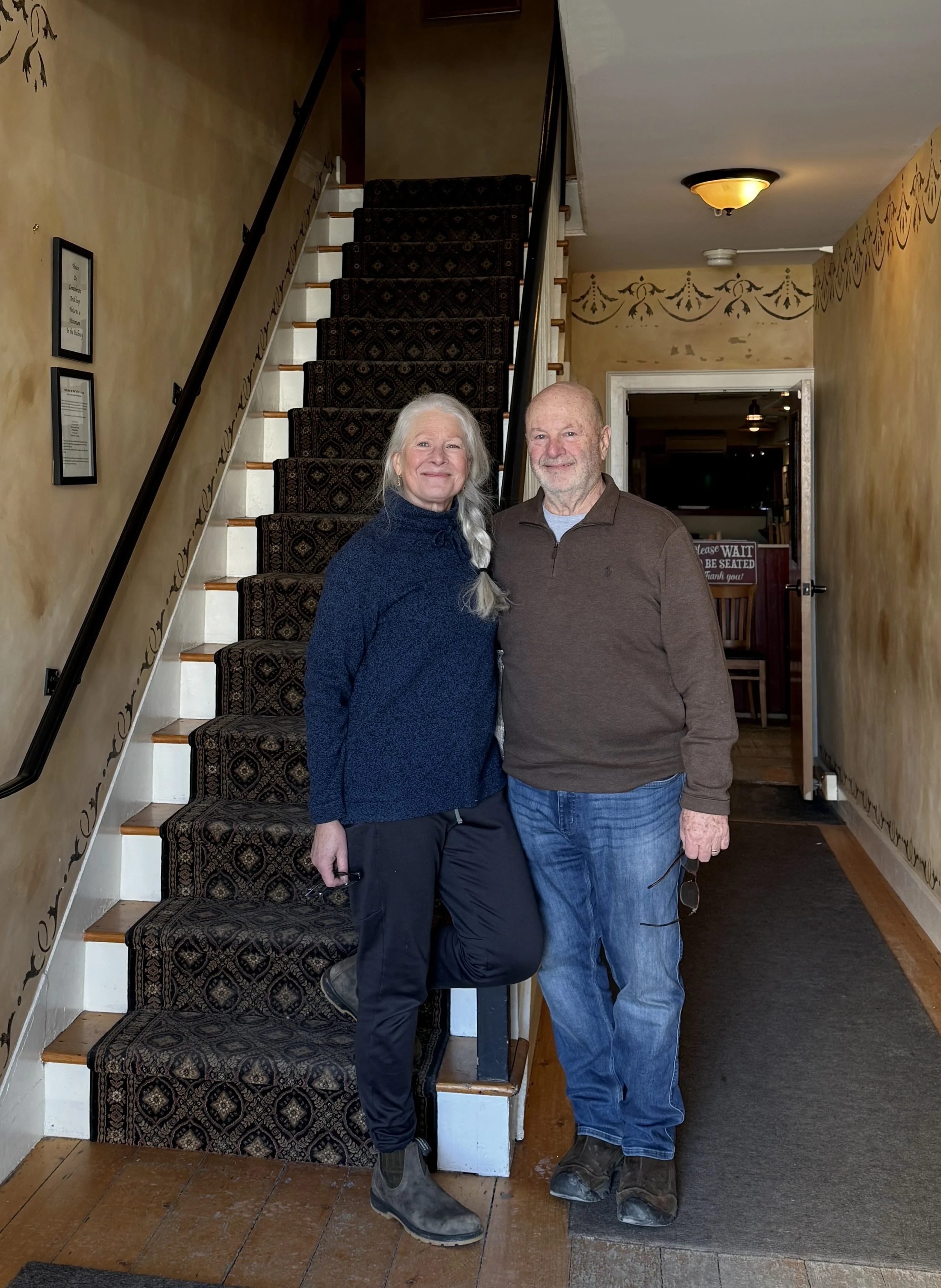 Innkeepers Laura and Paul Biron at Butler House in Stowe Vermont standing in historic interior entryway