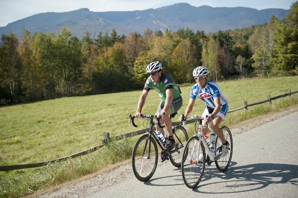 Cycling in Stowe Vermont along scenic country road with mountain views and fall foliage