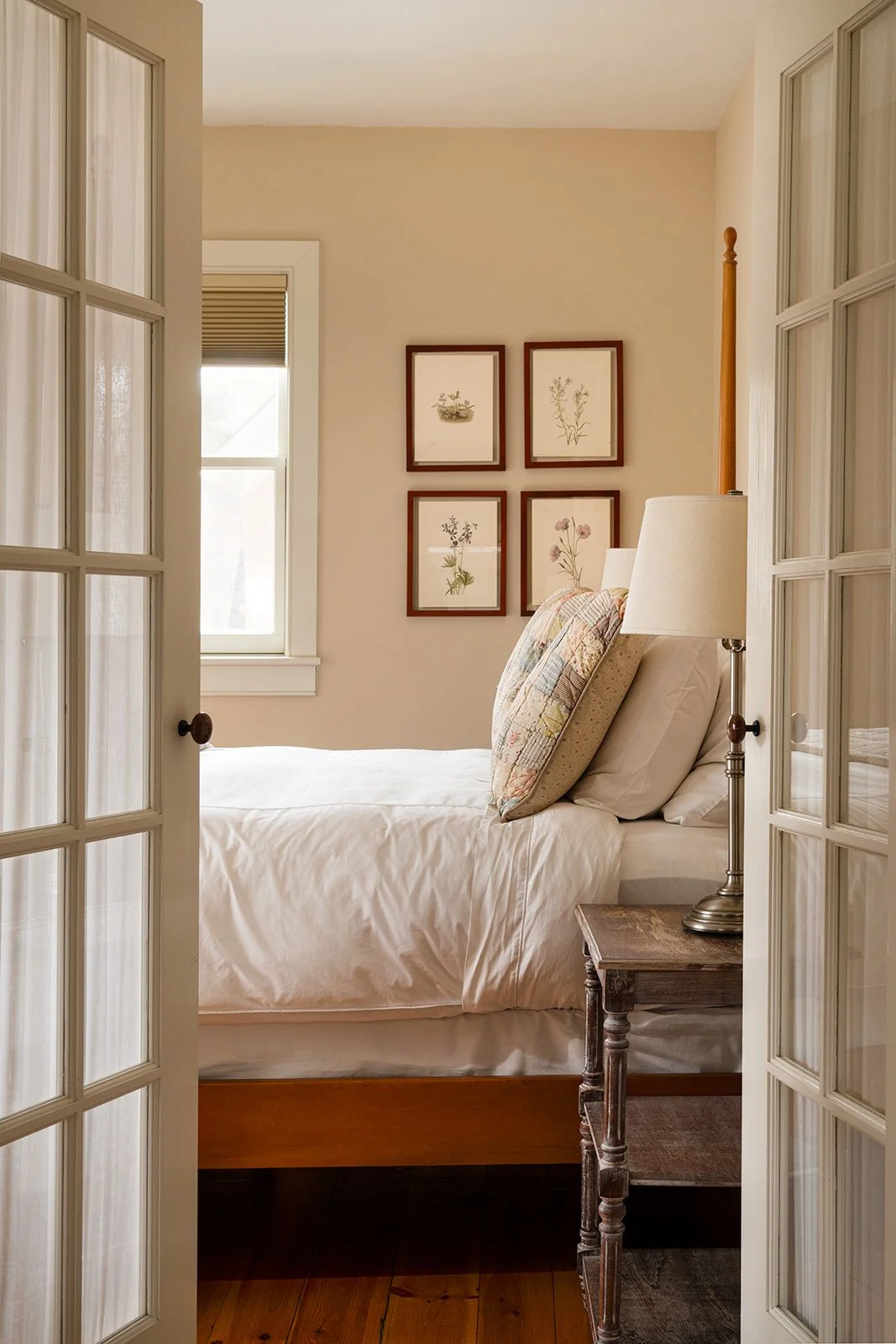 French door entry to bedroom in Butler's Hideaway featuring soft lighting and classic New England decor