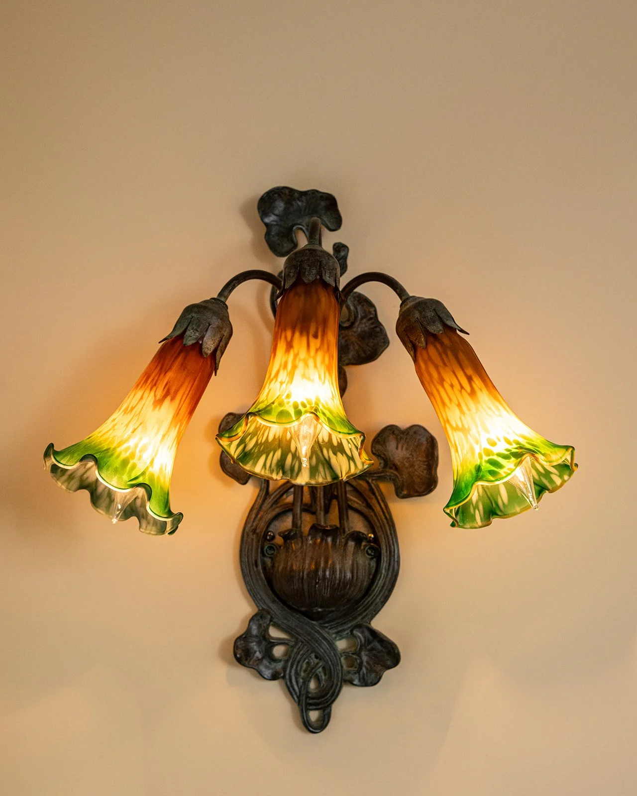 Vintage wall sconce with stained glass detail in Sarah's suite highlighting historic character of Butler House Stowe