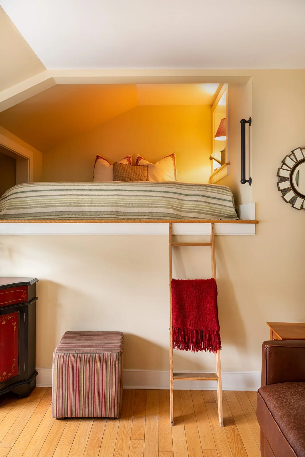 Lofted Queen bed in Zoe's Loft with ladder access, soft lighting and charming cottage style