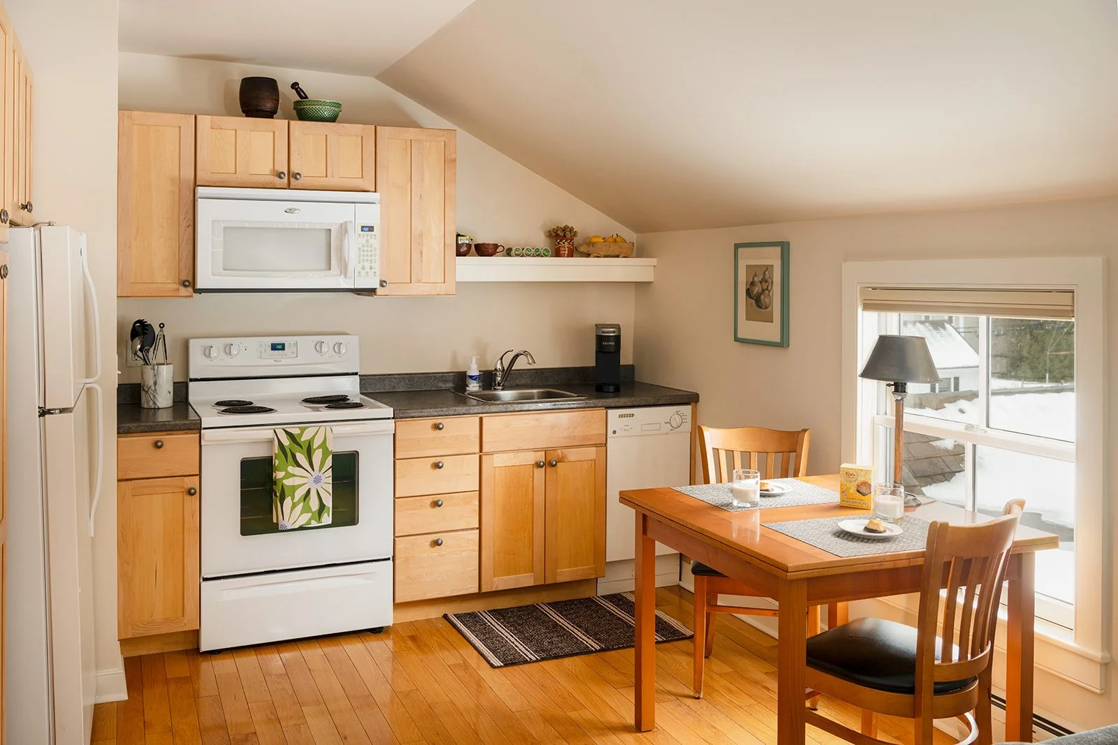 Full Kitchen and dining area in Max's Roost Stowe Vermont with wood cabinetry and table for two